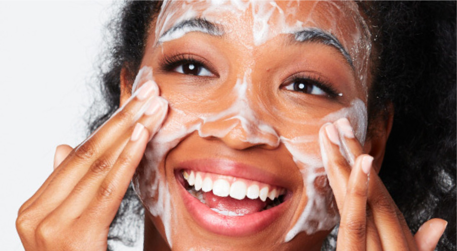 African American woman with foaming lather on her cheeks as she uses Olay Cleansing Melts to cleanse her face